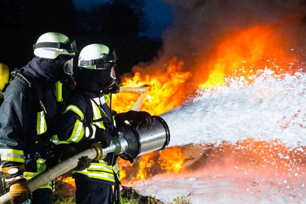 Firefighter Firemen Extinguishing A Large Blaze They are Standing